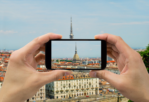 Tourist man taking photo in with smartphone in Torino
