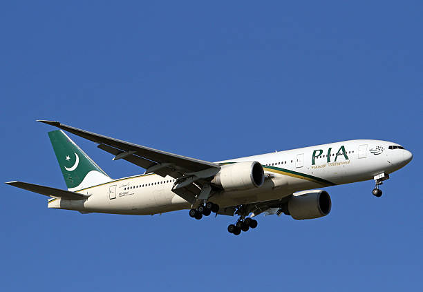 Pakistan International Airlines Boeing 777-200LR Manchester International Airport, England, United Kingdom - March 11, 2014. Pakistan International Airlines Boeing 777-200 on approach to land. lahore pakistan photos stock pictures, royalty-free photos & images