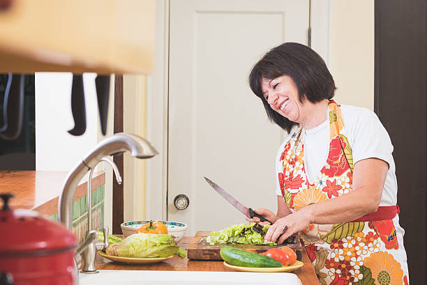 istock Woman Laughing While Chopping Lettuce in Kitchen 479940938