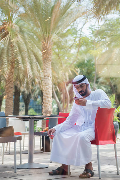 istock Traditionally Dressed Arab Businessman Texting on Cellphone at Outdoor Patio 479945266