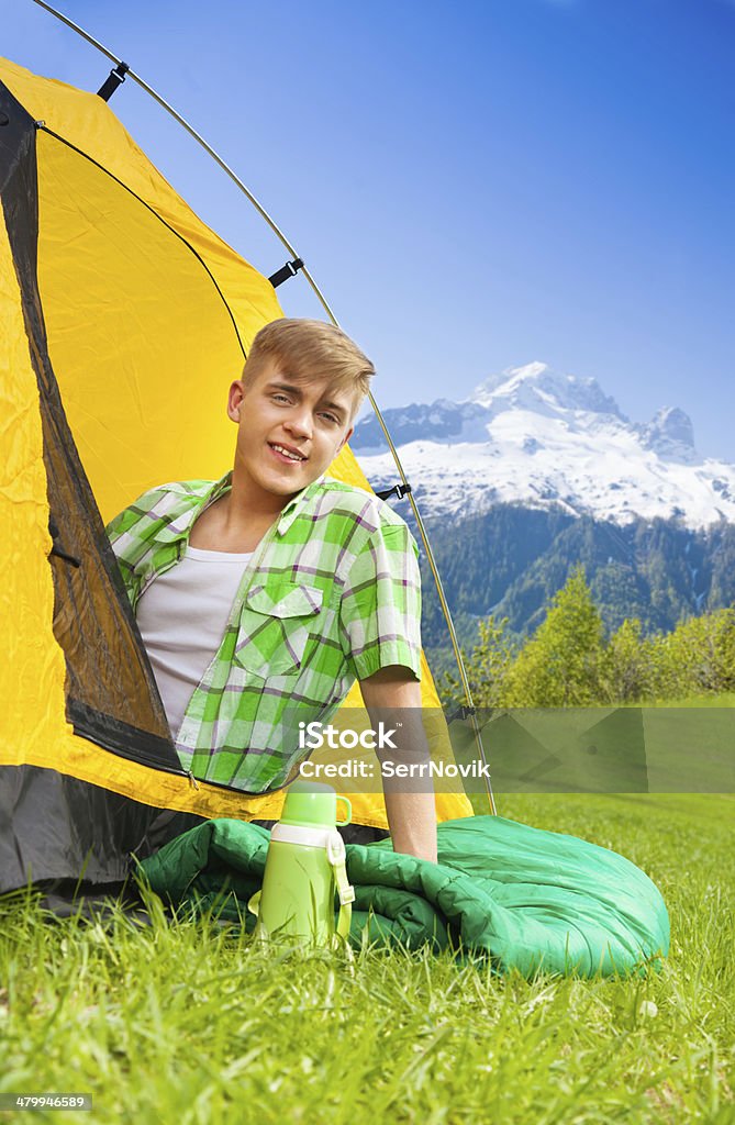 Young man on sleeping bag Beautiful young man with red hair in a tent smiling, on her hiking trip Activity Stock Photo