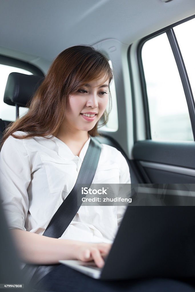 Beautiful asian young woman using laptop in car 2015 Stock Photo