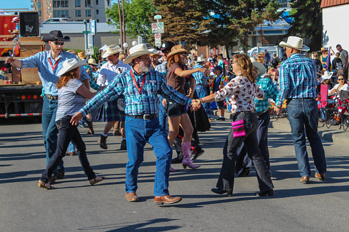 Calgary, Canada - July 4, 2014:  Fluor Square Dancers on the street doing the traditional square dance during the Calgary Stampede Parade, a community-based event designed to entertain Calgary families and visitors