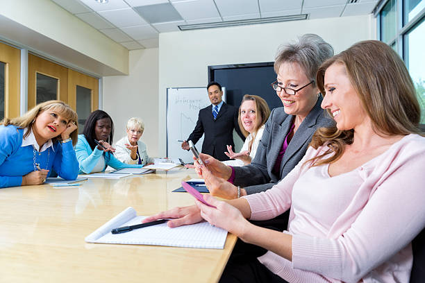 두 여자대표 살펴보고 휴대폰, 비즈니스 회의에서 - inconvenience meeting business distracted 뉴스 사진 이미지
