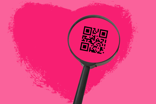 In the image we present a  magnifying glass, amplifying a QR Code of a lovely heart and when you read de code you will read the phrase ¨I Love You¨