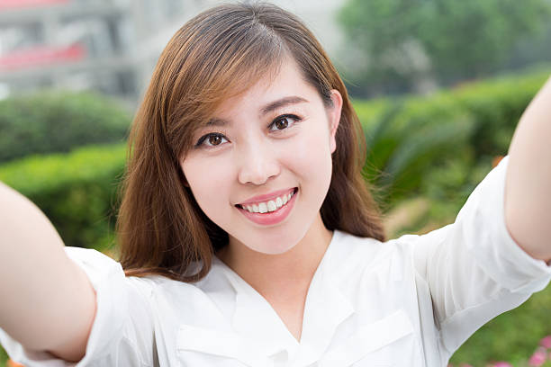 istock asian beautiful young woman using mobile phone to take selfie 479958388