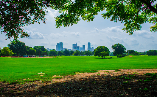 Zilker Park Summer Field Green Grass Austin Texas Skyline Fun. Everyone loves going to Zilker Park , fly a kite , go to the kite festival , blues on the green , live music , Austin is the live music capital and Zilker Park is the place to hear it. Volley ball , crowds of People and fun times , 
