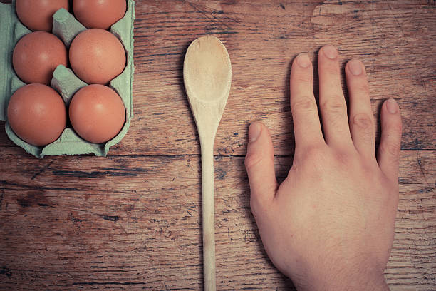istock Hand with eggs and wooden spoon 479963163