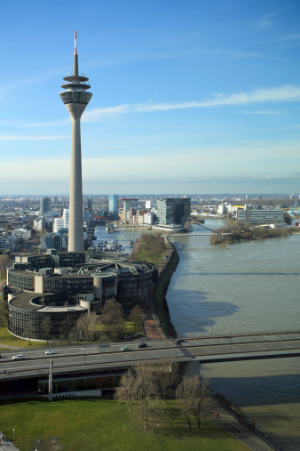 Duesseldorf media harbor with the Rheinturm tower and parliament of North Rhine-Westphalia in the front.