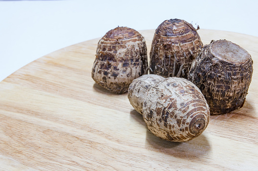 cooked taros with rough shell on wood block