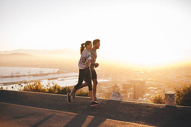 istock Young couple jogging on hillside road 479966116