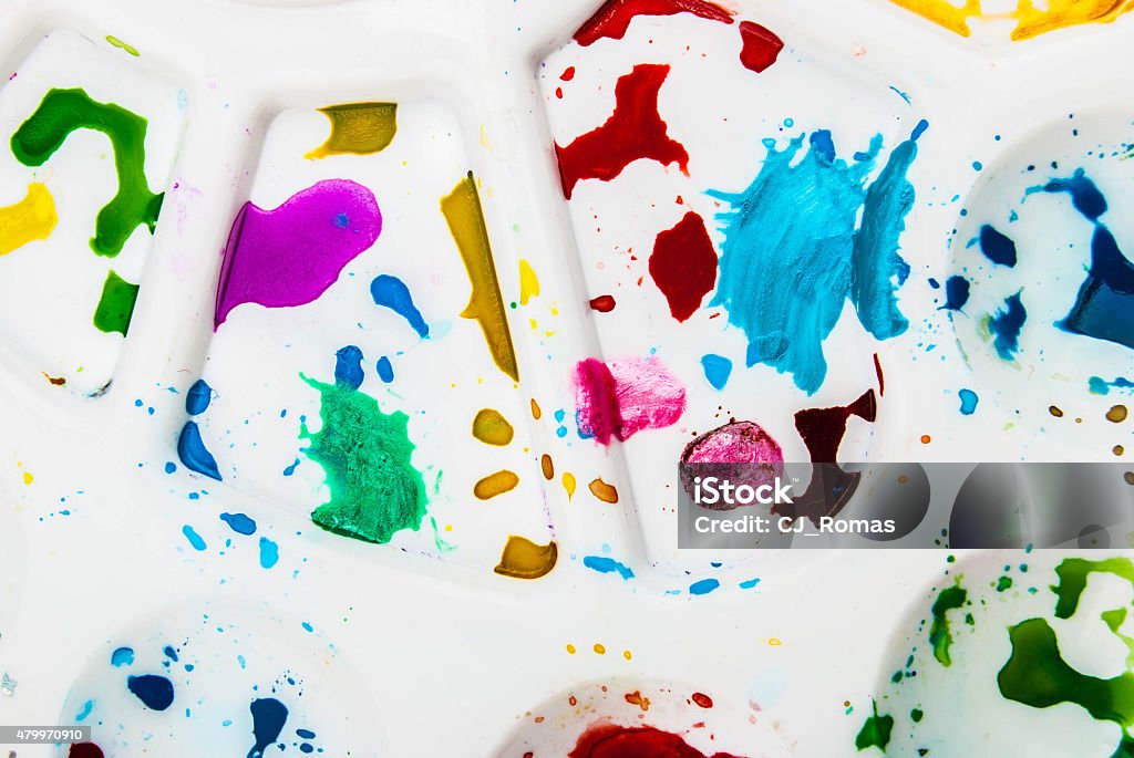 Palette White plastic art palette with random watercolor paint blobs on wood 2015 Stock Photo