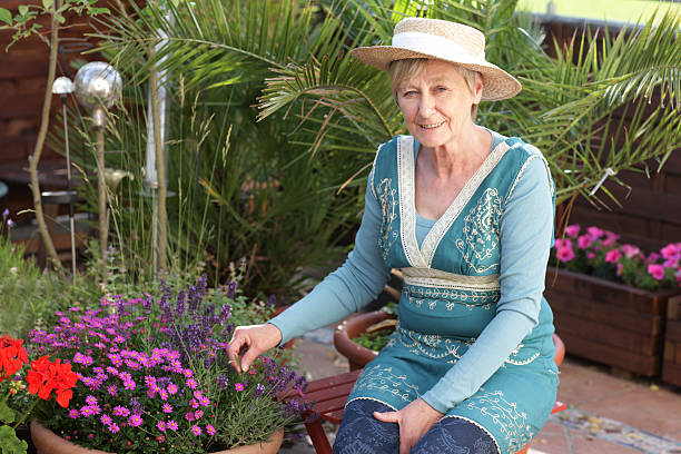 istock Happy senior woman with flowers 479971414