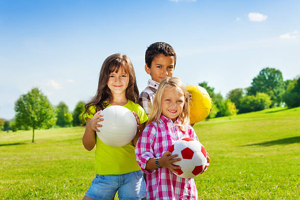 istock Team of three happy kids with balls 479972075