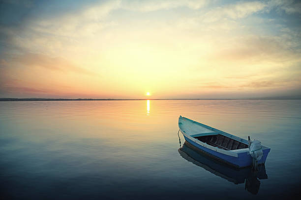 istock Canoe floating on the calm water under amazing sunset 479976808