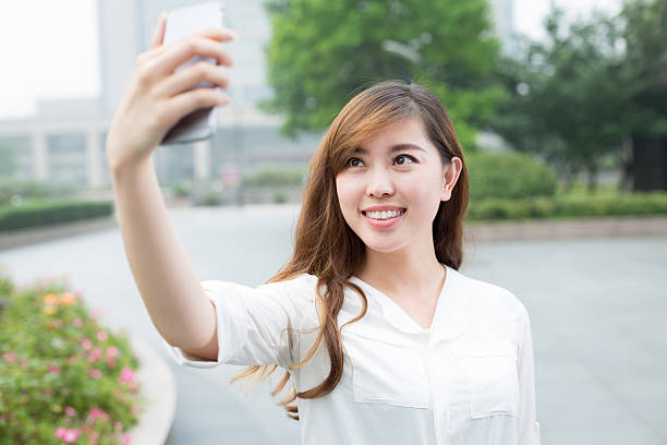 istock asian beautiful young woman using mobile phone to take selfie 479979074
