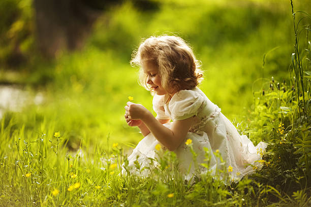 heureuse petite fille avec une fleur - formal garden ornamental garden child single flower photos et images de collection