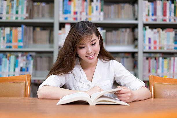 istock Beautiful asian female student read book in library 479985948