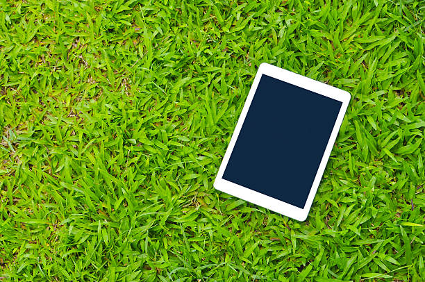istock Tablet on green grass background with copy space 479990624