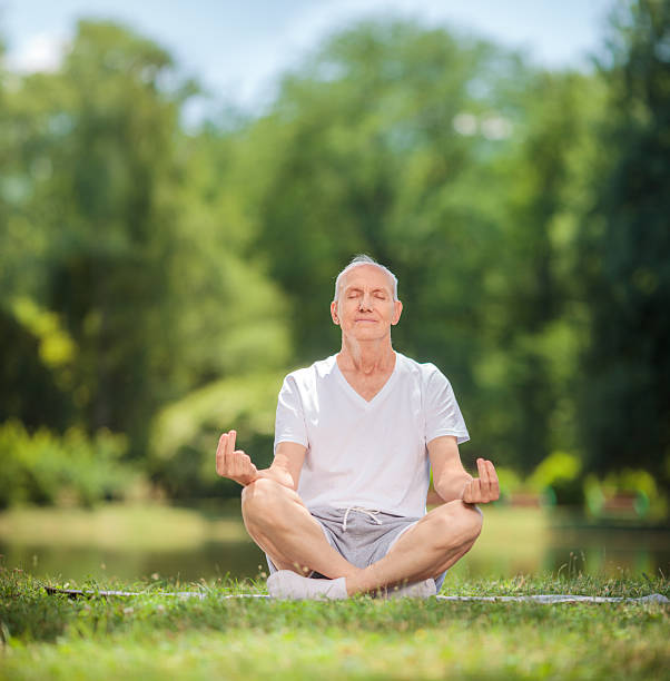 istock Peaceful senior man meditating seated in a park 479998738