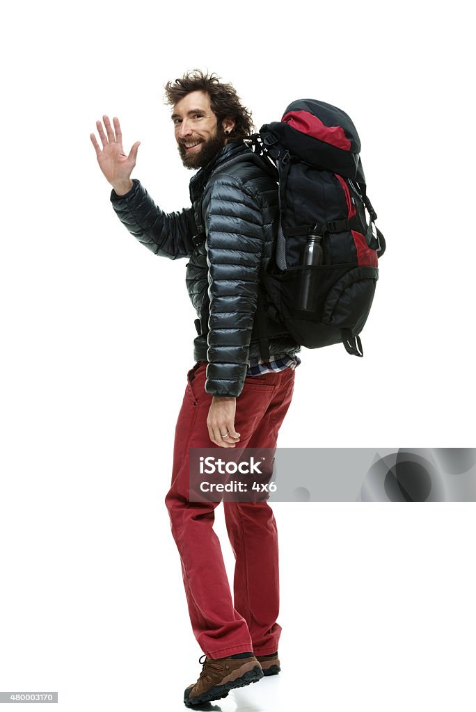 Smiling male hiker waving hand and walking Smiling male hiker waving hand and walkinghttp://www.twodozendesign.info/i/1.png Cut Out Stock Photo