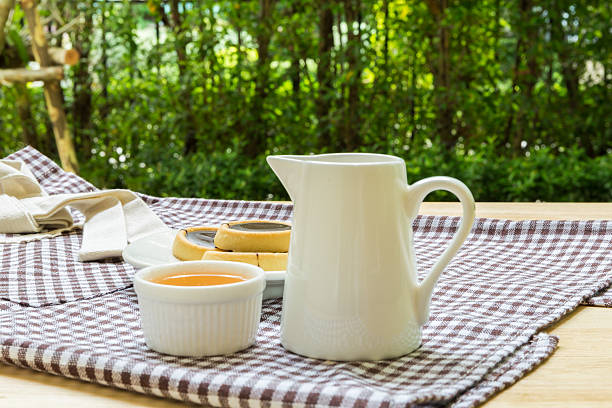 White jug on old wooden table over green background