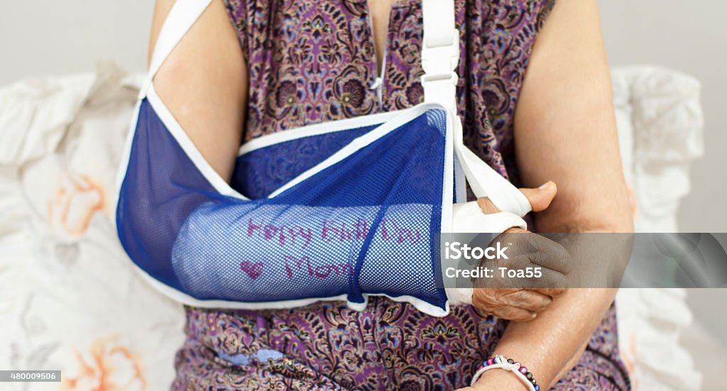 elderly woman with a broken arm on plaster cast Happy birthday elderly woman with a broken arm on a plaster cast 2015 Stock Photo