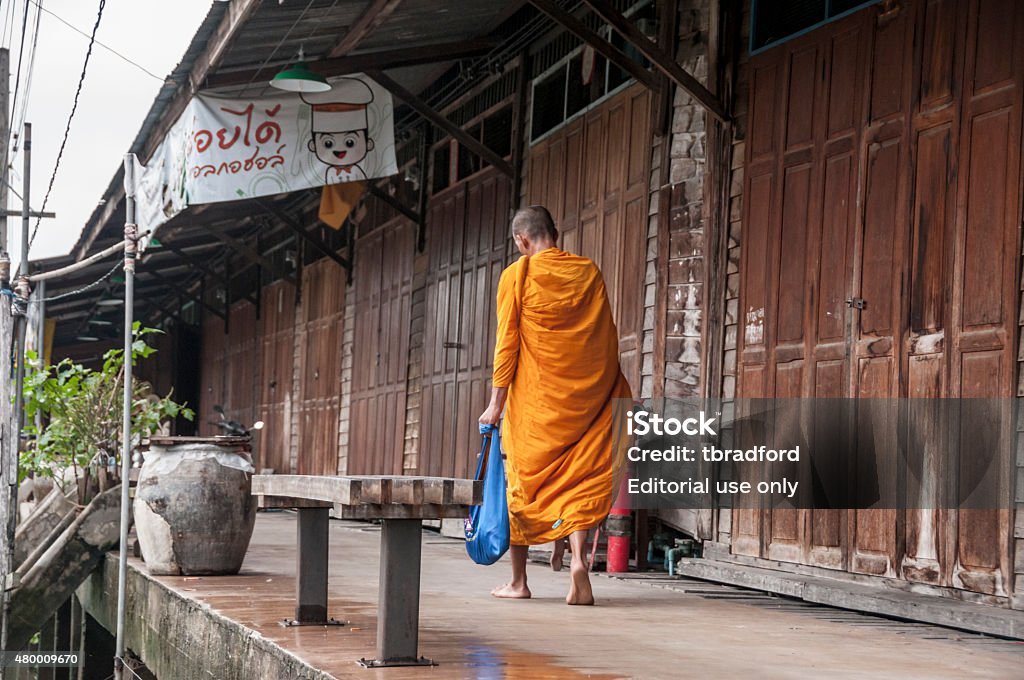 Buddhist Monk Amphawa, Thailand - July 22, 2011: A Buddhist monk on his daily alms round at Amphawa in Thailand. In Theravada Buddhism, monks go on a daily alms round (or pindacara) in the morning to collect food. This is thought to make merit for the giver Monk - Religious Occupation Stock Photo