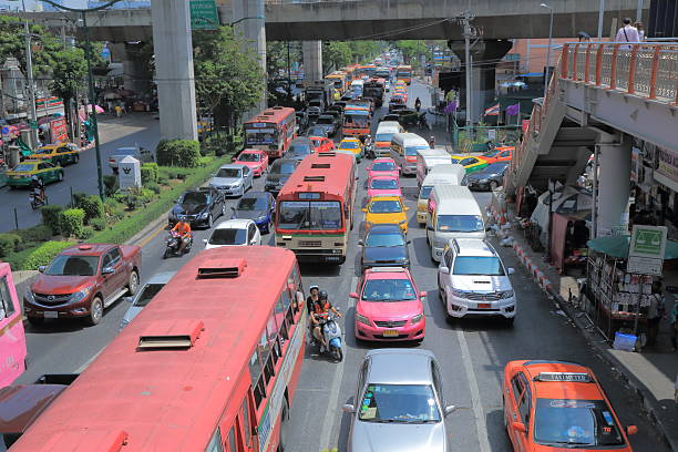 Bangkok Thailand - April 19, 2015: Buses and cars drive through heavy traffic in downtown Bangkok Thailand. 