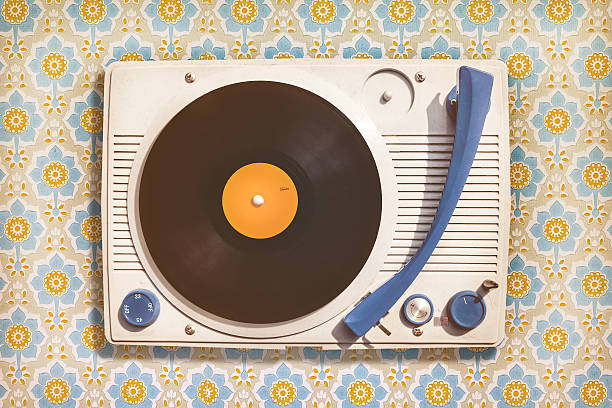 Vintage record player on top of flower wallpaper Retro styled image of an old record player on top of flower wallpaper record player stock pictures, royalty-free photos & images