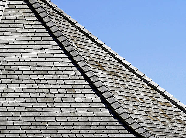 istock Weathered Cedar shingles on roof - blue sky background 480011990