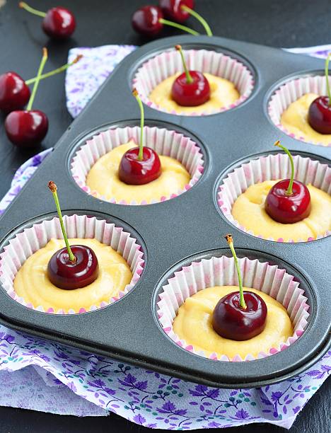 raw muffins with cherry. Ready for insertion into the oven.