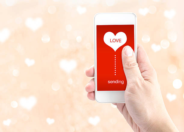 istock Hand holding smartphone with sending word and heart shape 480018420