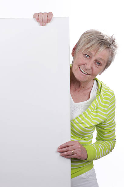 istock Happy older woman behind a white board 480022478