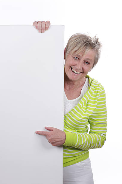 istock Happy older woman behind a white board 480026534