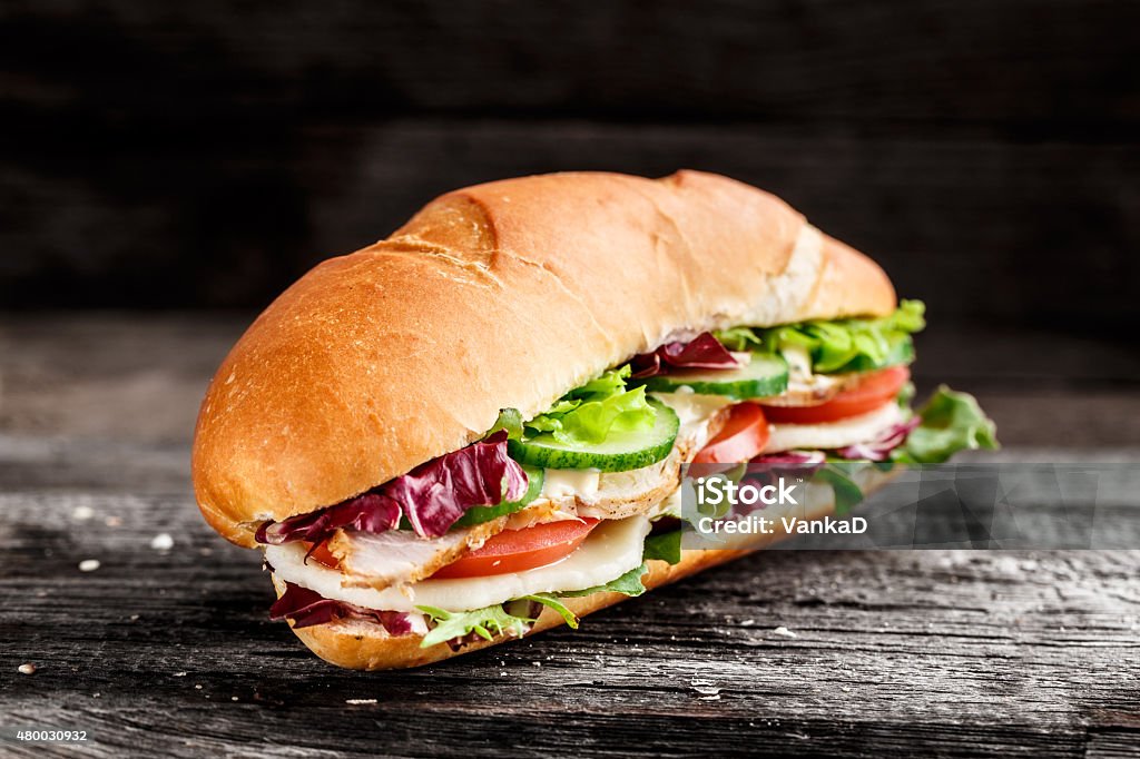 Sandwich with chicken, cheese and vegetables Sandwich with chicken, cheese and vegetables on a rustic background 2015 Stock Photo