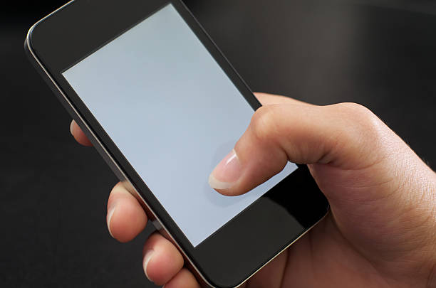 senhora hält mobiltelefon em einer mão de mulher segurando cellphone - anwendung imagens e fotografias de stock