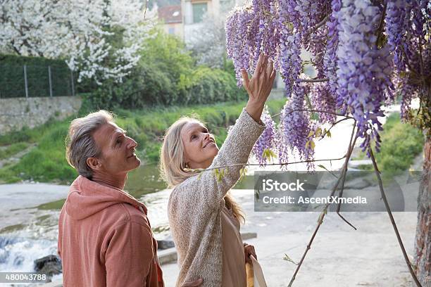 Couple Gaze Up At Flowers In Liguria Italy Stock Photo - Download Image Now - 2015, Adult, Beautiful People