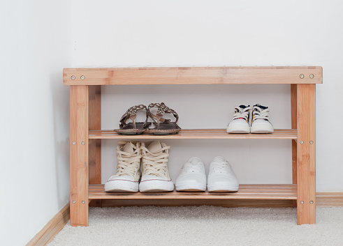 Old vintage wooden bench with shoes shelf, storage of shoes on the shelf