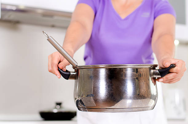 istock Woman holding out a metal saucepan 480047620