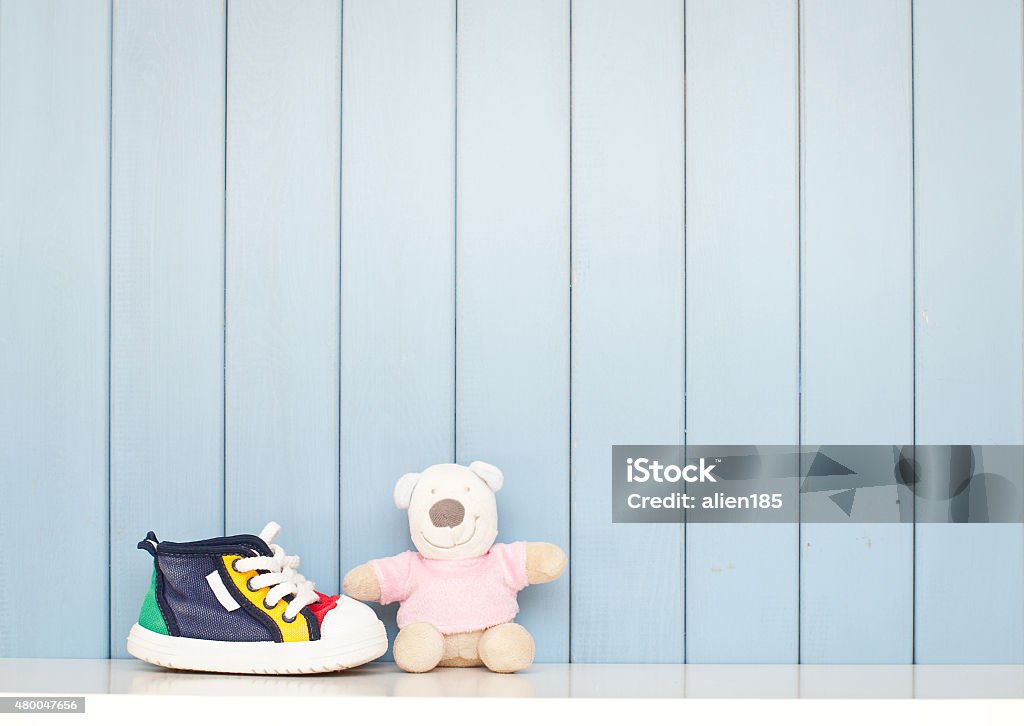 Baby shoes Tiny baby shoes and teddy bear on the table in baby's room Canvas Shoe Stock Photo