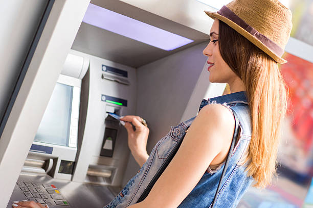 istock Young smiling woman withdrawing money from ATM. 480048028