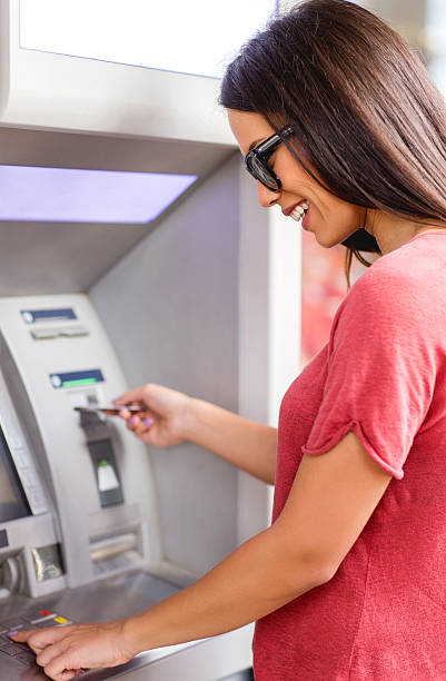istock Young happy woman withdrawing money from ATM. 480048090
