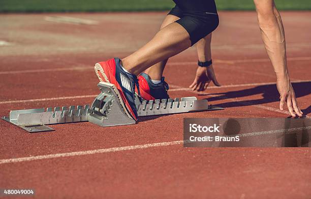Unrecognizable Man Preparing To Start A Race On Running Track Stock Photo - Download Image Now
