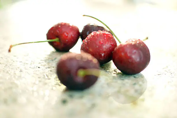 Freshly washed sweet red cherries on marble counter in afternoon