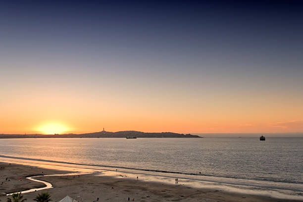 Sunset at La Serena, Coquimbo, Chile. View of silhouette of Coquimbo harbour from the beach.