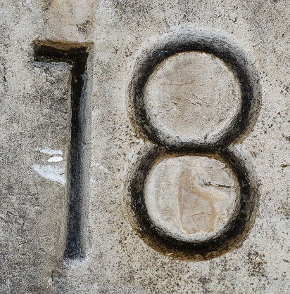 number 18 etched in rough grungy wall background