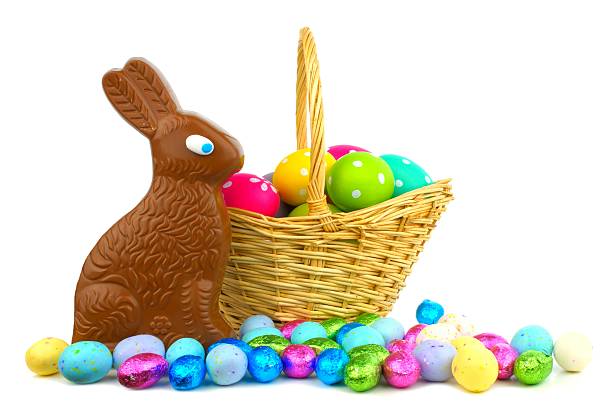 Easter basket filled with eggs and sweets Chocolate bunny and candy with Easter basket over white chocolate bunny stock pictures, royalty-free photos & images