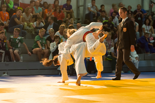 Alkmaar, the Netherlands - June 25, 2015: Two female judoka captured during the competition at the International Children Games 2015 in Alkmaar the Netherlands.The athlete in blue belt is about to score an ippon point. ICG is an international sports competition for children between 12 and 15 years old. In 2015 it has been held in Alkmaar.