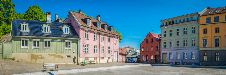 Brightly coloured townhouses and wooden villas overlooking a tranquil sunny square in a quiet residential district of Oslo, Norway's picturesque capital city. ProPhoto RGB profile for maximum color fidelity and gamut.